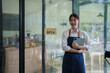 © Tj - Young woman entrepreneur welcoming customers to cafe