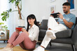 © Studio Marmellata - A young couple enjoys a moment of fun playing video games together in a bright, modern living room.