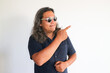 © bima - Asian man showing a direction with point finger on an siolated white wall