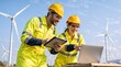 © Vasiliy - Smiling male and female engineers using a laptop and tablet at a wind farm. Team of technicians in high-visibility uniforms and hard hats working on renewable energy project