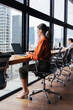 © Stock 4 You - Latin hispanic young business woman working on laptop computer at office desk. Full body vertical portrait of manager businesswoman using pc for work, sitting at window with skyscraper city view