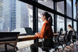 © Stock 4 You - Latin hispanic young business woman working on laptop computer at office desk. Indian entrepreneur manager businesswoman using pc for work, doing analysing, sitting at window with skyscraper city view