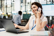 © DC Studio - Businesswoman talks on mobile device with partner, managing negotiations and collaborating on sales agreements. Focused female employee communicating in office, closing business deals on phone call.