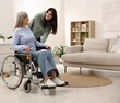 © New Africa - Senior woman in wheelchair with her caretaker at home