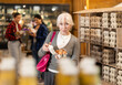 © JackF - Elderly female customer selects and buys chicken eggs at a grocery supermarket