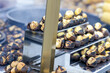 © Sanlad - Close-Up of Roasting Chestnuts at Street Vendor Stall