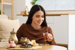 © Pixel-Shot - Young woman with Turkish tea and delight on table at home