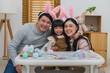 © geargodz - father, mother and daughter wearing bunny ears smiling happily while celebrating together at home on easter day. happy family holiday activity concept