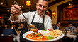© Aura - A happy male chef in a restaurant dining room holding a plate of butter chicken curry served with white rice green chutney and garlic naan
