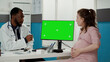 © DC Studio - Medical specialist using computer with greenscreen at desk, consulting pregnant woman. Medic and patient looking at blank copyspace with isolated chroma key and mockup template.