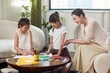 © Blue Jean Images - Mum watching daughters doing art homework