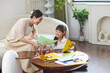© Blue Jean Images - Mum helping girl doing her art homework