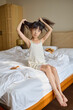 © Blue Jean Images - Girl brushing her hair after waking up