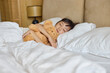 © Blue Jean Images - A girl sleeping in bed with a toy bear in her arms