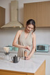 © Blue Jean Images - A beautiful woman making coffee by hand