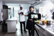 © DC Studio - Woman expert provides professional cooking techniques for web master class. With a camera filming every step, the culinary school lesson brings gourmet skills to a global audience.