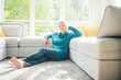 © Westend61 - Portrait of smiling woman relaxing in living room