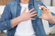 © auremar - young man using asthma inhaler at home
