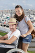 © auremar - woman pushing man in wheelchair by the harbour
