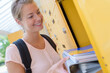 © auremar - smiling student keeping her book in the locker in university