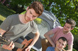 © auremar - young men camping one playing guitar