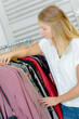 © auremar - Woman picking out clothes in a shop