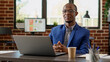 © DC Studio - Portrait of african american worker sitting at office desk, using laptop to work on executive project with website statistics. Company manager analyzing research report, typing email on browser.