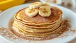 © Creative Insights - A delicious stack of fluffy pancakes generously topped with sliced bananas and dusted lightly with rich cocoa powder.