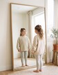 © Marina - Plus-size girl wearing oversized sweater looking in mirror at home
