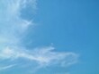© Eka - White wispy clouds on a clear blue sky background. Perfect for nature backgrounds, weather-related themes, and creative design projects