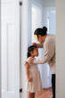 © NZstockphoto - Young Samoan girl standing against the wall while mum measures her height