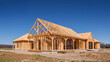 © janzwolinski - New house framing construction in progress against a clear blue sky