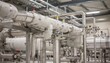 © DigitalSpace - Medium shot focusing on insulated piping systems designed for monomer transfer highlighting thermal protection and safety features in an indoor chemical processing area.