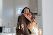 © NZstockphoto - Young maori girl seated on kitchen counter hugging mum
