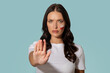© Home-stock - Woman with flag of Poland on cheek standing with her hand in stop gesture, posing over blue background