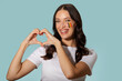 © Home-stock - Happy lady forming heart shape with her hands, showing love to Romania, posing with flag painted on her cheek and smiling