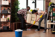 © DC Studio - Multiracial couple doing spring cleaning at home, african american husband lifts heavy living room sofa for wife to clean underneath. Couple taking care of household chores together.