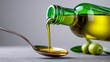 © Nataliia_Trushchenko - Golden olive oil pours from green bottle into metal spoon. Fresh olives rest beside bottle on grey surface. Scene suggests healthy cooking or gourmet food preparation. Ideal for recipes, wellness