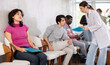 © JackF - Thoughtful young girl sitting in clinic queue while nurse speaking to other patients in background