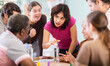 © JackF - Group of different ages playing board game at table in office