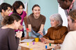 © JackF - Group of different ages playing board game at table in office