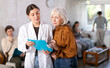 © JackF - Elderly woman talks to a nurse in the reception area after a job interview.