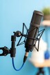 © AlAmin - Professional studio condenser microphone with shock mount and blue cable on a bright background.