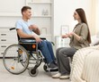 © New Africa - Man in wheelchair with woman at home