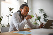 © Studio Marmellata - A man with braided hair, wearing a white shirt, sits at a desk with a laptop and a pencil in his mouth, deep in thought.