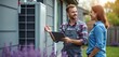 © Vadym - Technician shows homeowner tablet data near heat pump. They discuss system operation and maintenance. Home energy efficiency improvement consultation.
