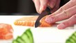 © Cavan - Professional chef slicing fresh raw salmon on a white cutting board