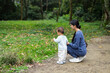 © leungchopan - Mother and baby enjoying forest nature adventure walk