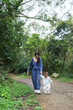 © leungchopan - Mother holding baby discovering forest nature outdoor