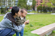 © leungchopan - Mother and baby blowing dandelions in park